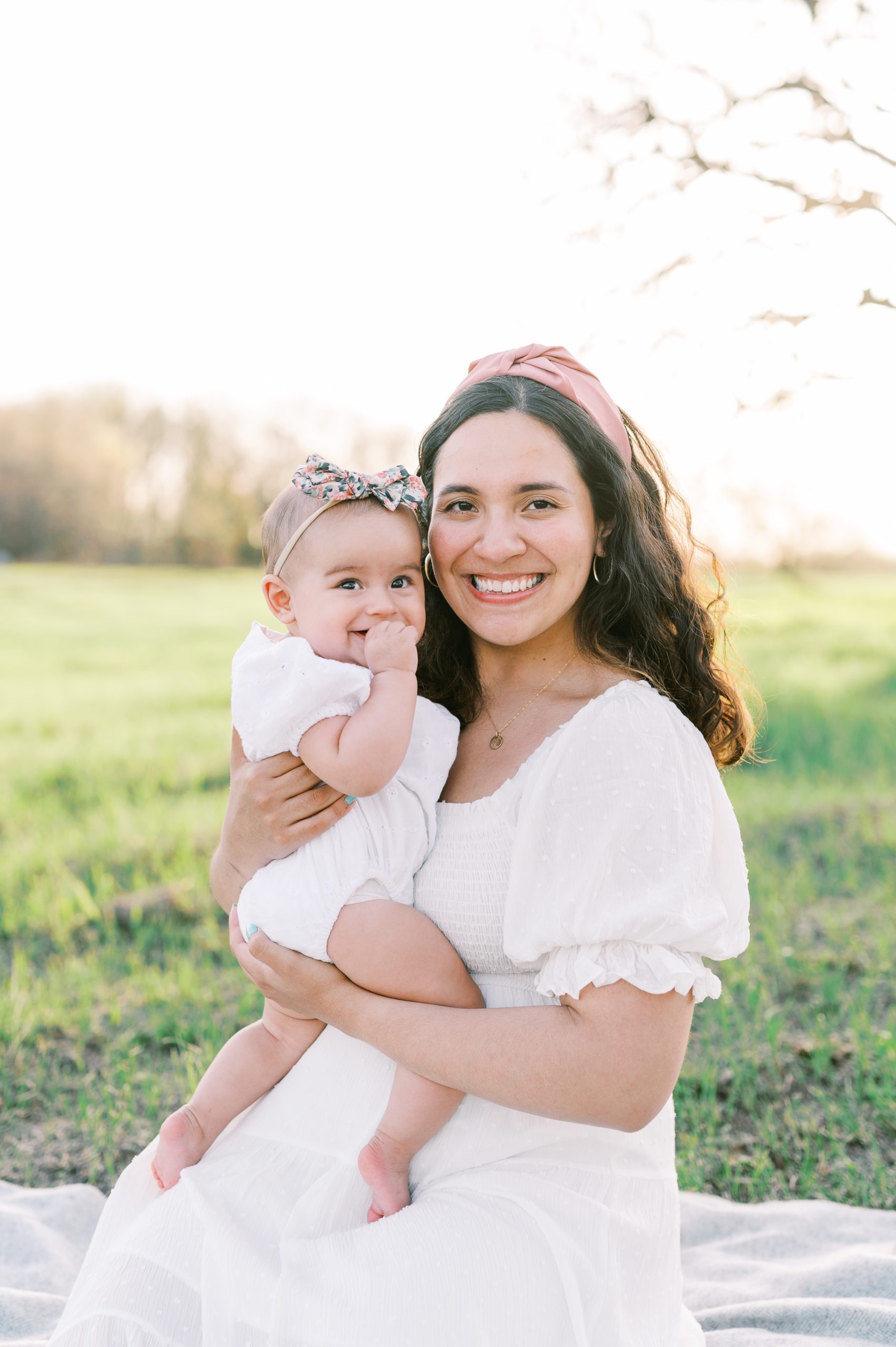 mom with baby girl in white flowing dress at sunset in a Minneapolis field