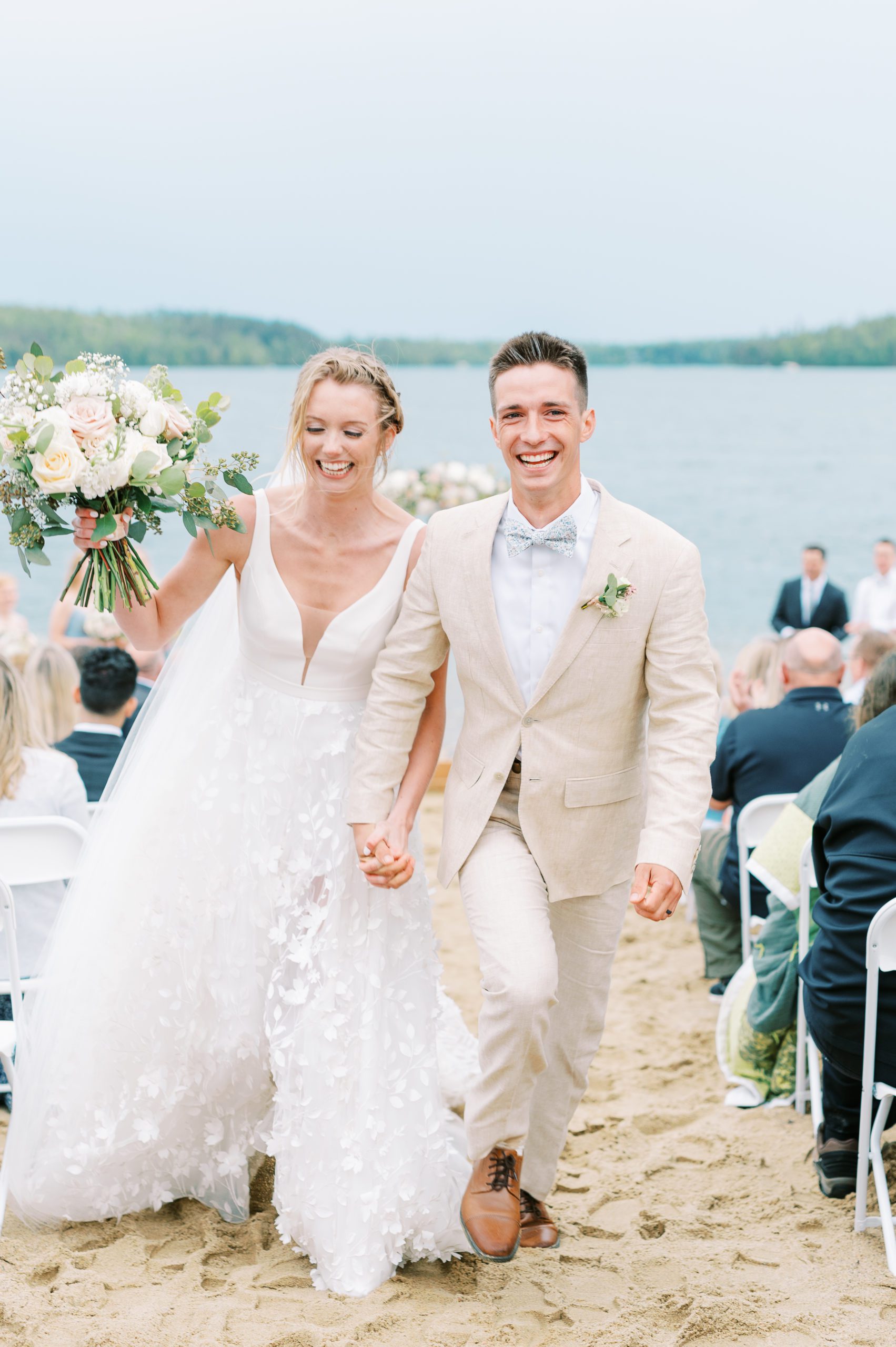 bride and groom come up aisle with happy emotions