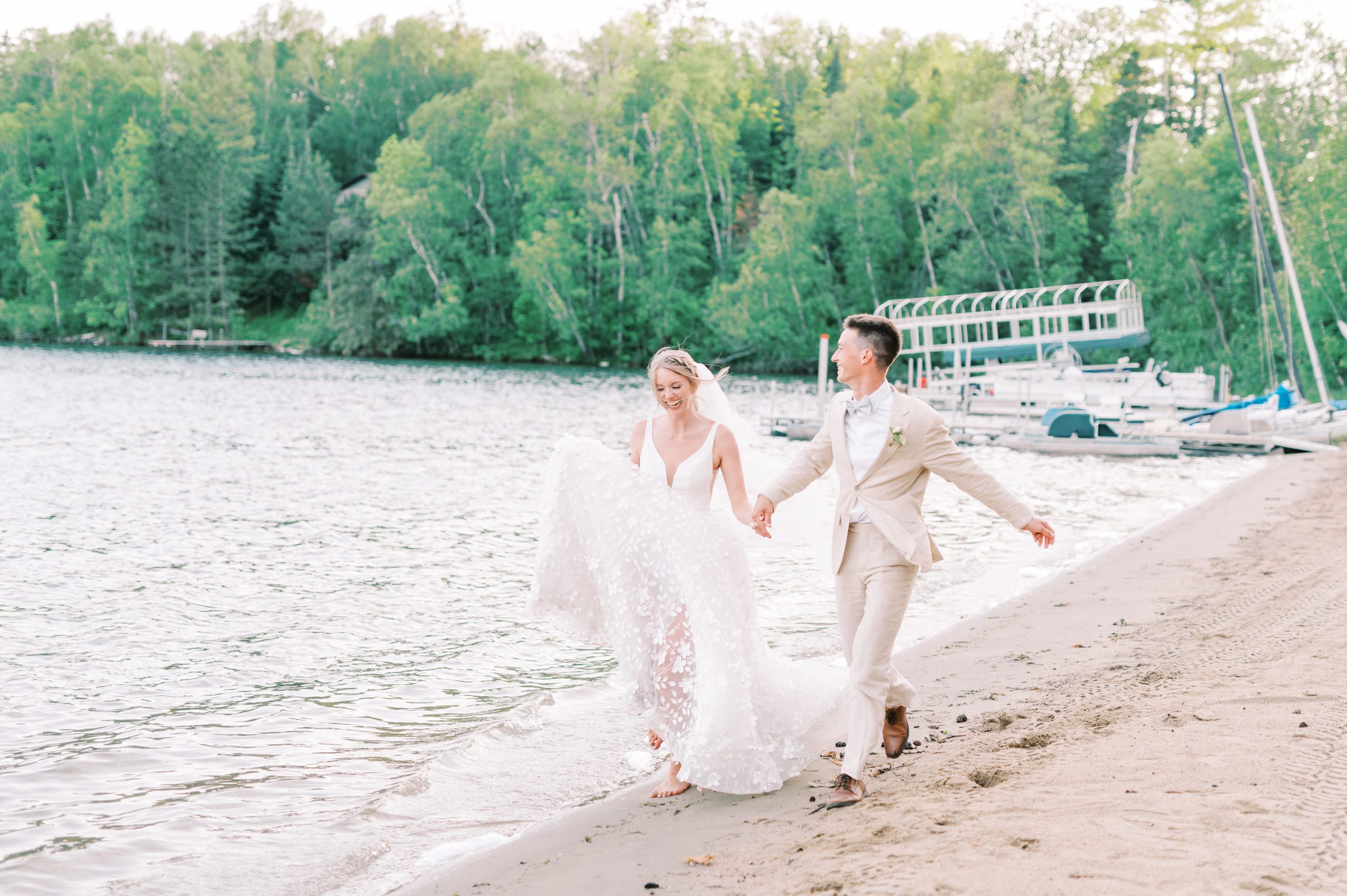 bride and groom run on beach