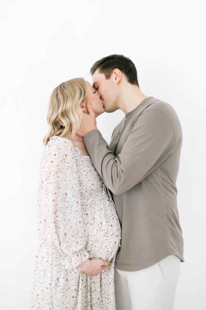 Mom and dad kissing at maternity session
