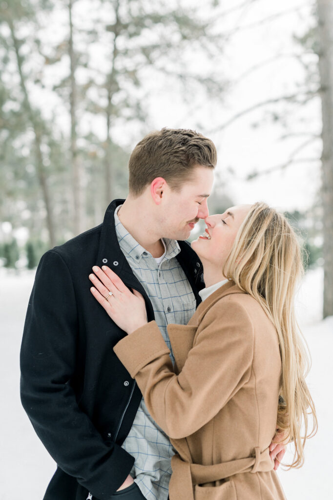 Winter engagement session couple standing facing each other