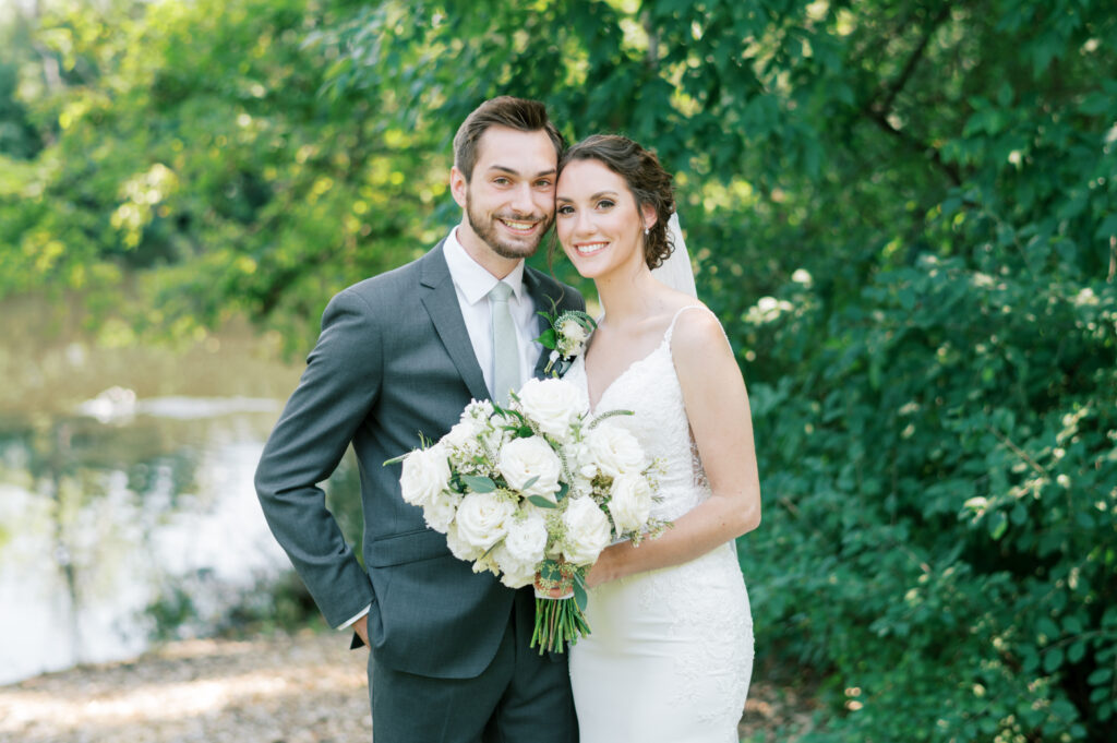 A couple standing together for a portrait at a summer wedding in Minnesota. 